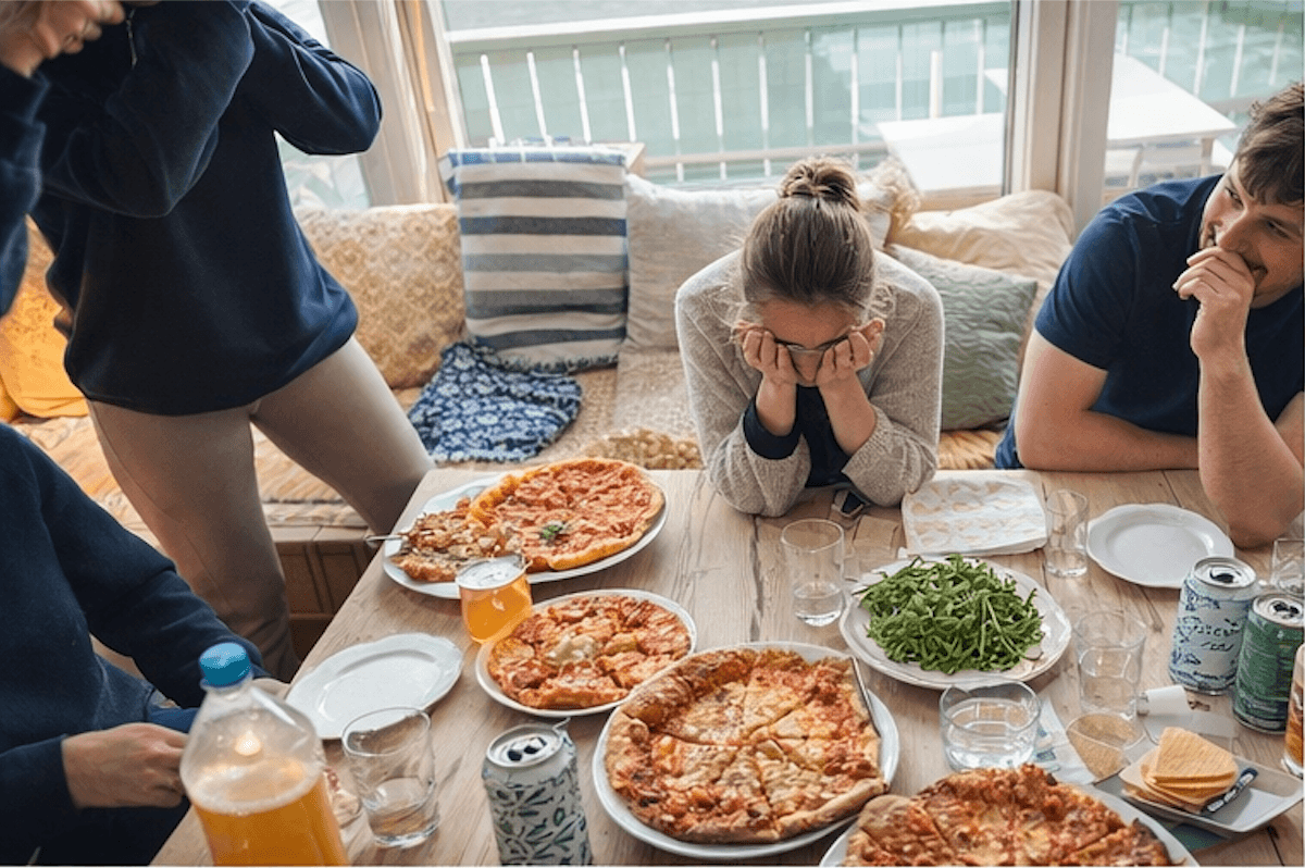 Venner samlet rundt pizzabord på hytta